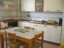 Kitchen of the Papavero Apartment with dinig table and chairs
