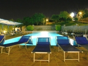 Swimming pool with deckchairs in the evening