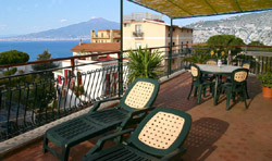 Apartment in Sorrento: Terrace od Rosy apartment with table and chairs and Vesuvius in the background